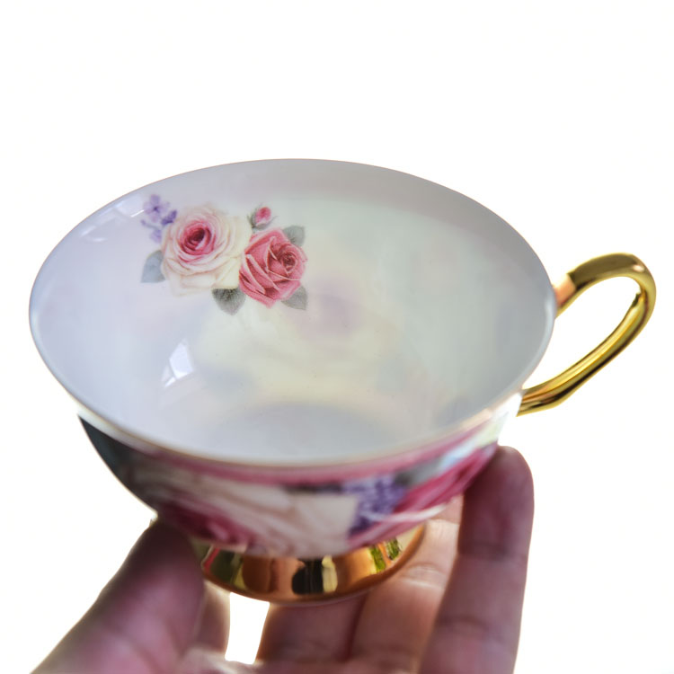 手托花卉图案咖啡杯,杯内可见玫瑰图案